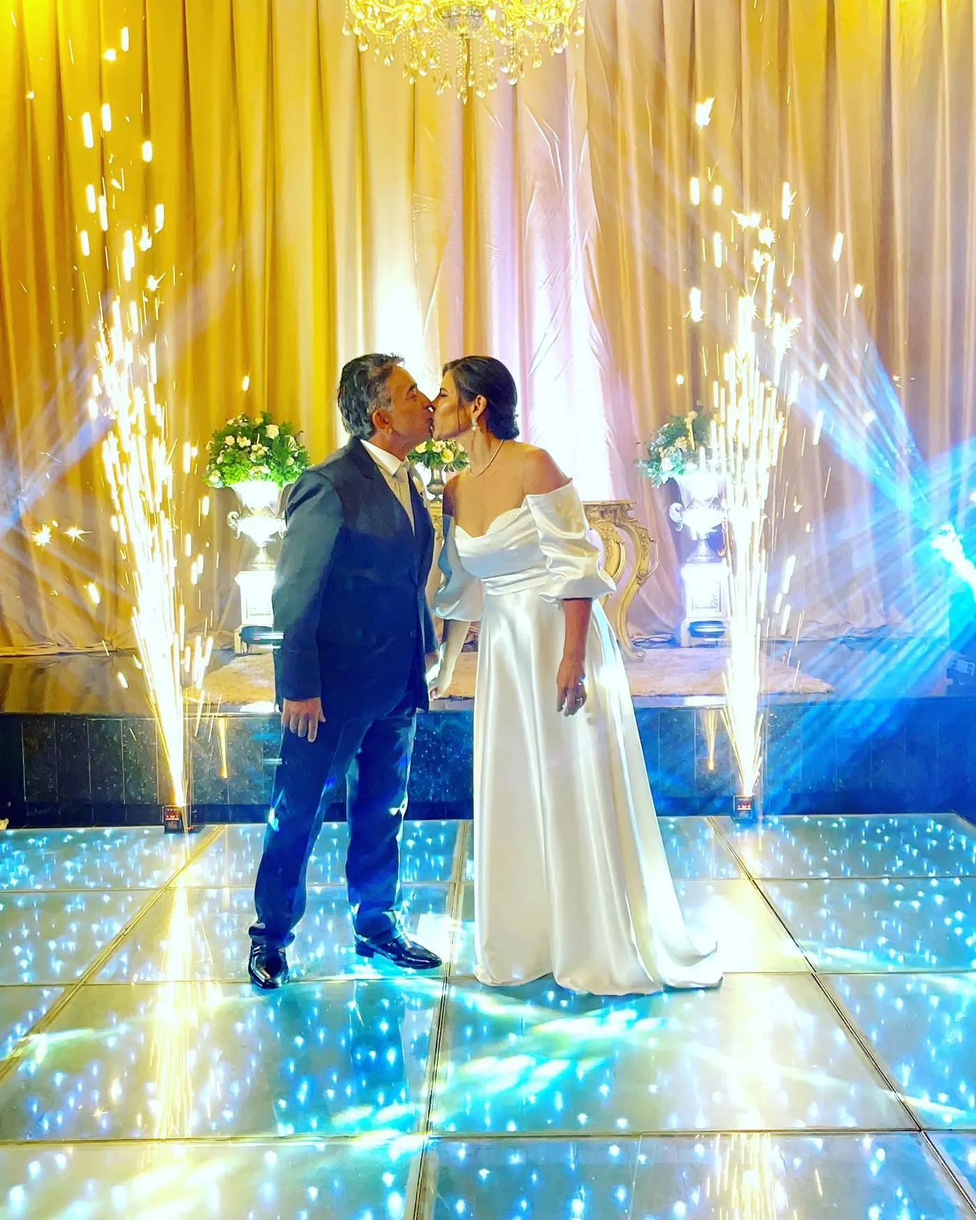 Noivos se beijando na pista de LED com efeito de faísca