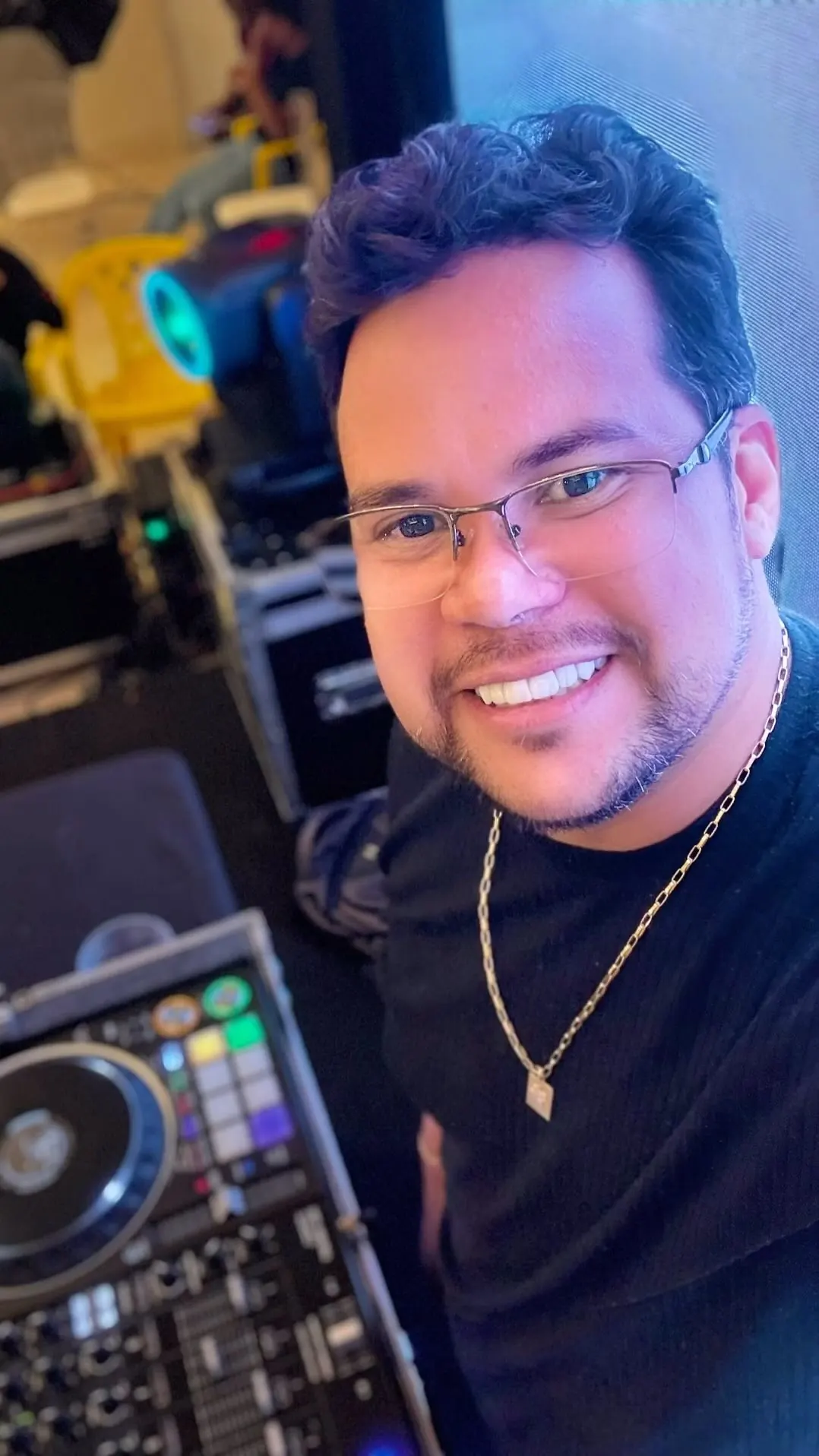 DJ Xandee sorrindo ao lado da controladora e dos movings